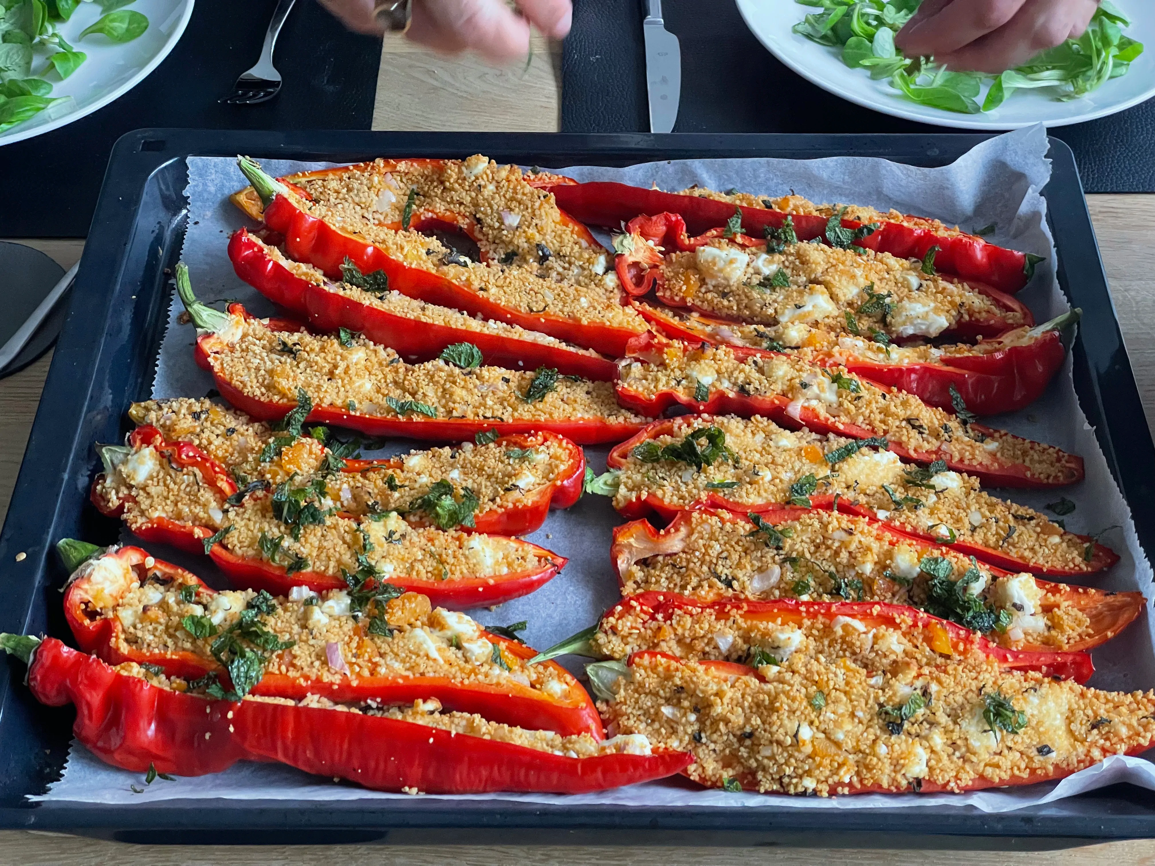 Oven-grilled pointed peppers filled with pearl couscous, feta and mint leaves